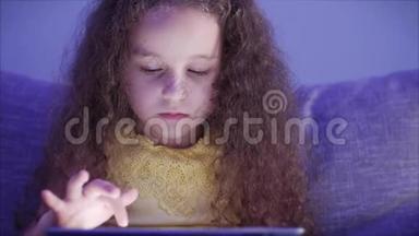 一个白种人<strong>可爱</strong>的孩子，一个<strong>小女孩</strong>，一个孩子的脸上贴着一个平板电脑看着`张<strong>照片</strong>的夜景画像